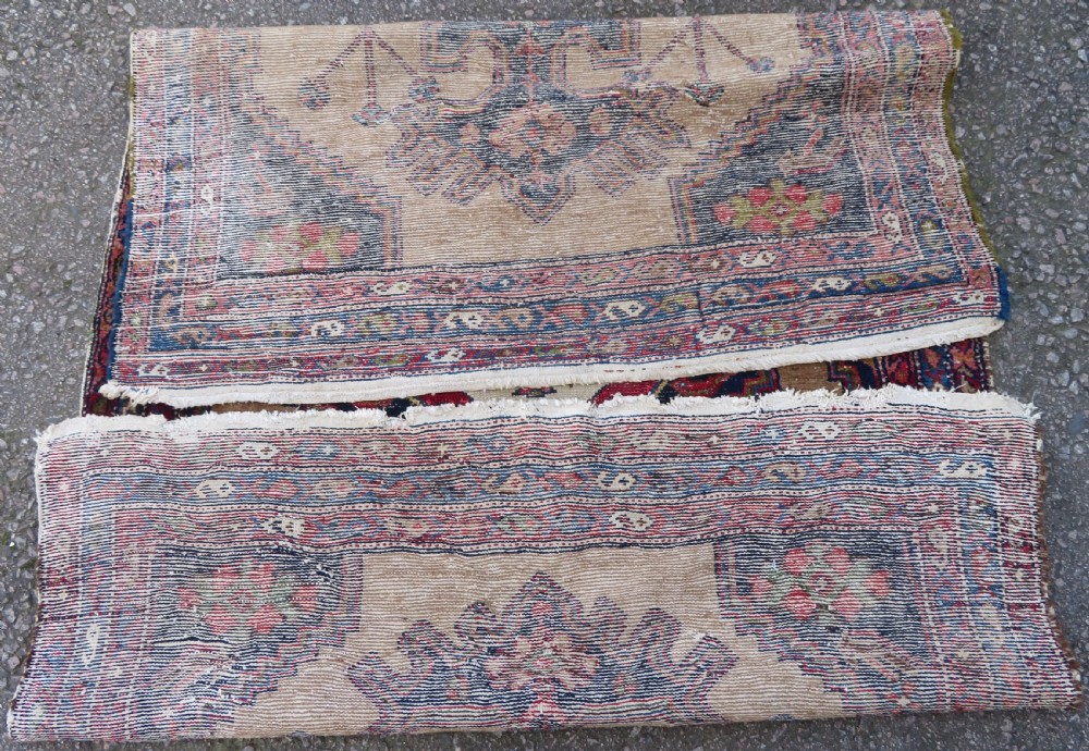 An antique hand-knotted Persian Hamadan wool rug featuring a geometric central medallion on a camel field with navy and red accents. View XI