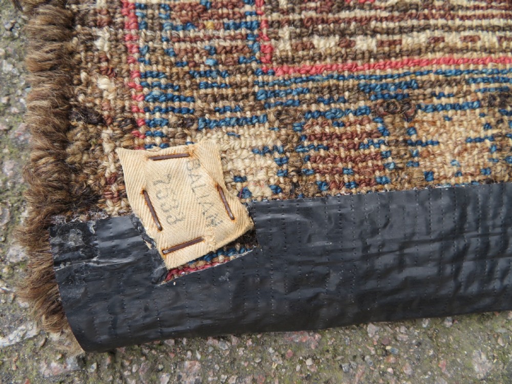 An antique Kurdish tribal rug featuring a cream field with stylized tree motifs, a central navy diamond medallion, and terracotta pink geometric borders. View XIV