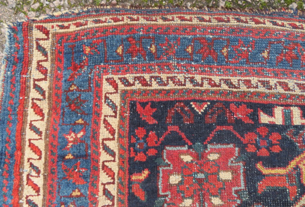 A rectangular hand-knotted antique Afshar rug featuring geometric floral motifs in terracotta red and sky blue on a deep navy blue background. View VIII