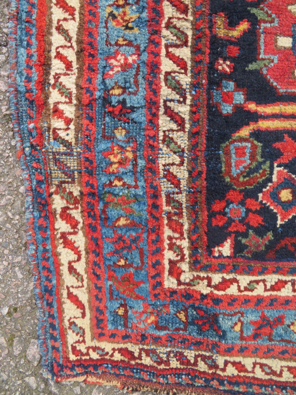 A rectangular hand-knotted antique Afshar rug featuring geometric floral motifs in terracotta red and sky blue on a deep navy blue background. View IX