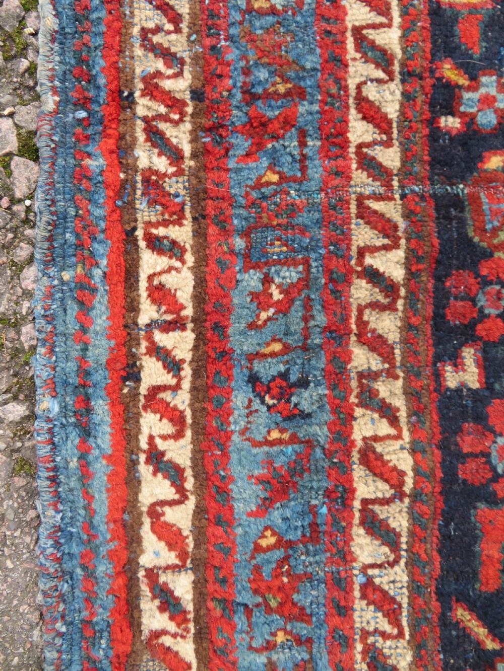 A rectangular hand-knotted antique Afshar rug featuring geometric floral motifs in terracotta red and sky blue on a deep navy blue background. View XI