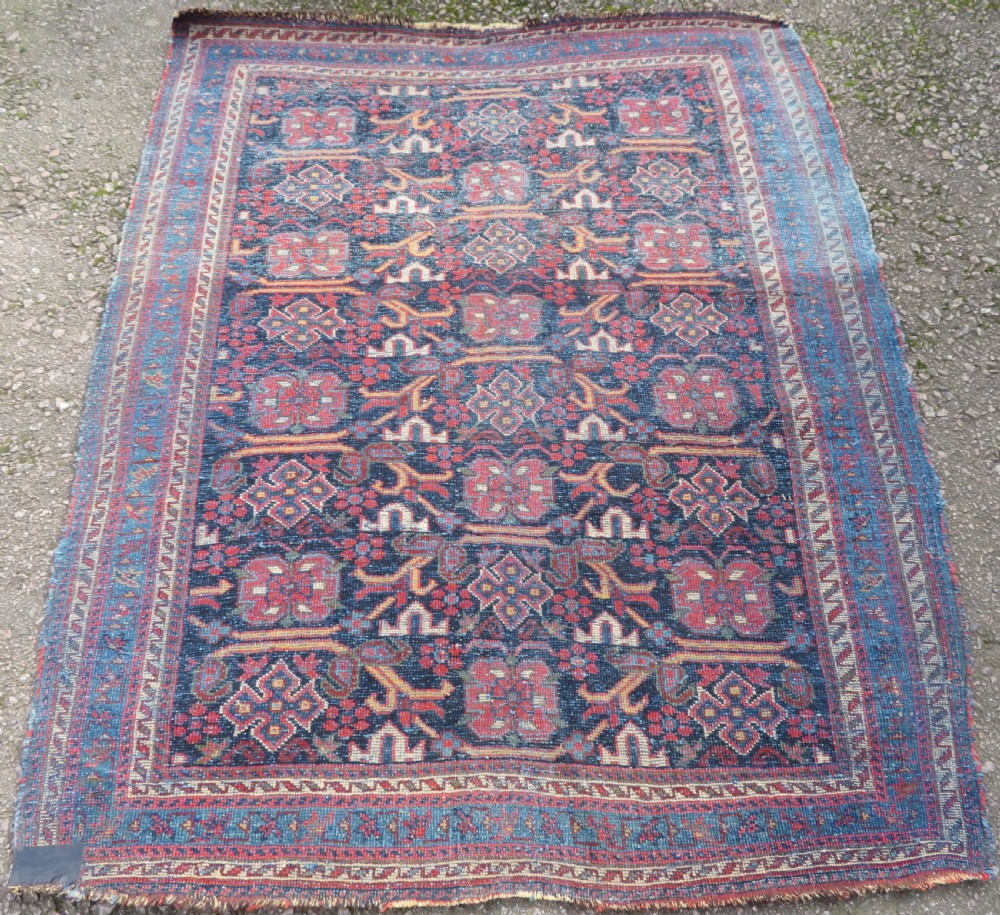 A rectangular hand-knotted antique Afshar rug featuring geometric floral motifs in terracotta red and sky blue on a deep navy blue background. View XII