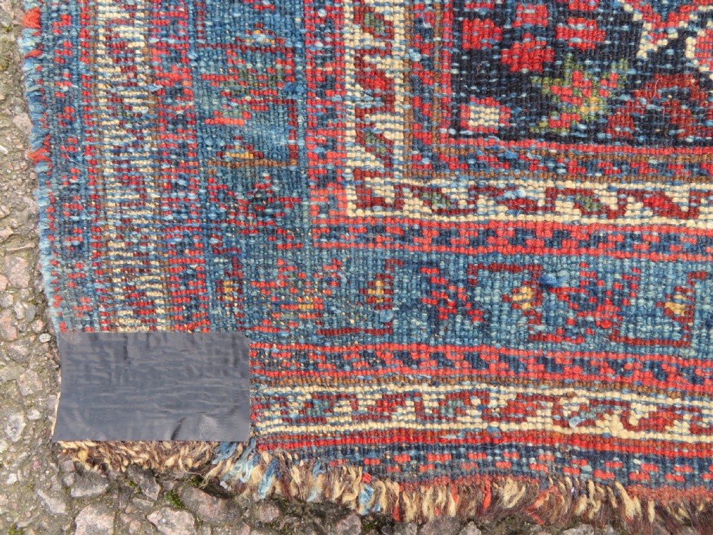 A rectangular hand-knotted antique Afshar rug featuring geometric floral motifs in terracotta red and sky blue on a deep navy blue background. View XIII