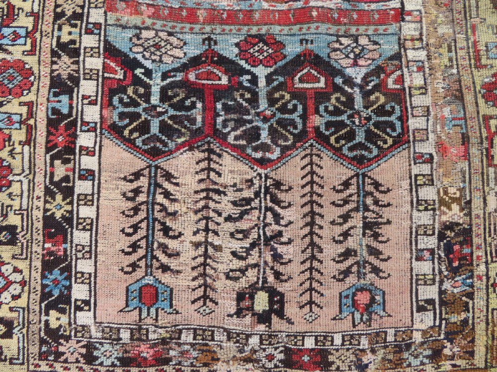 An antique hand-knotted Turkish Ladik wool prayer rug featuring a central pale blue mihrab niche, inverted tulip motifs, and multi-coloured geometric borders. View III