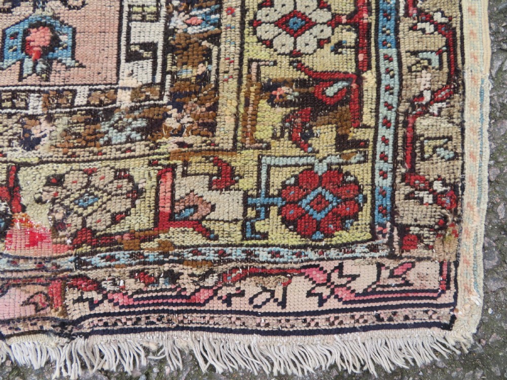 An antique hand-knotted Turkish Ladik wool prayer rug featuring a central pale blue mihrab niche, inverted tulip motifs, and multi-coloured geometric borders. View VI