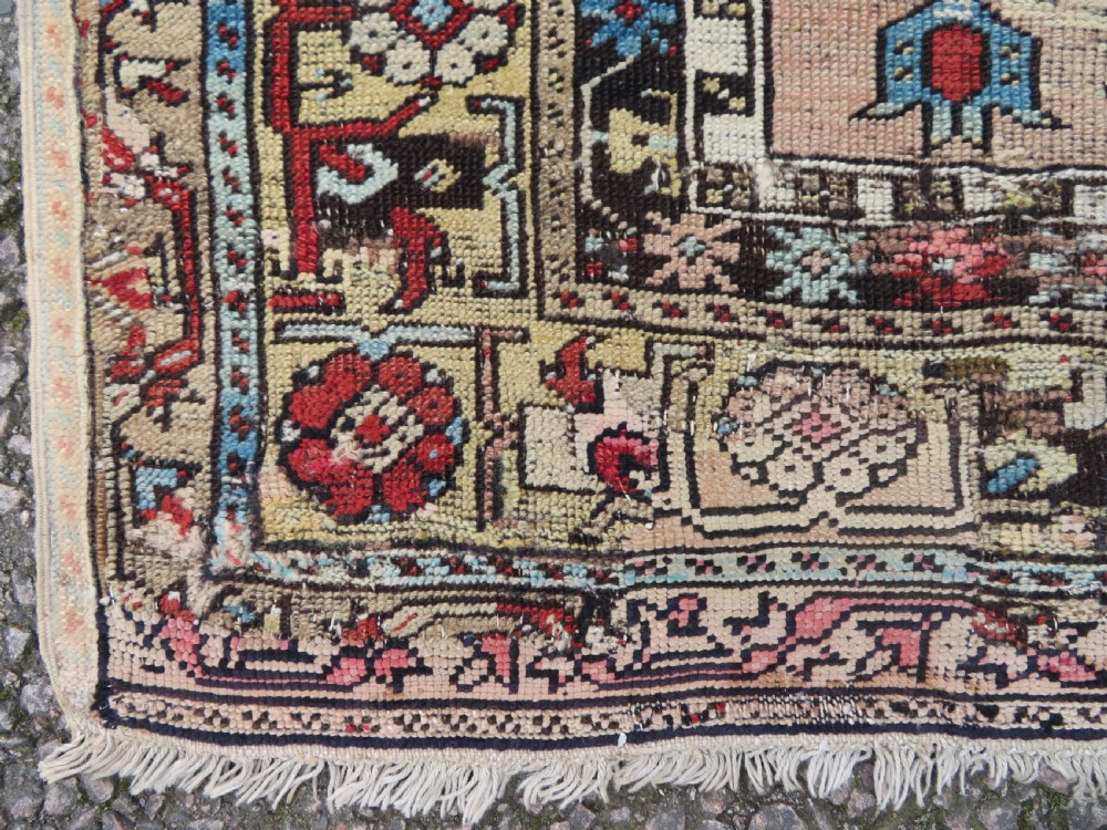An antique hand-knotted Turkish Ladik wool prayer rug featuring a central pale blue mihrab niche, inverted tulip motifs, and multi-coloured geometric borders. View VIII
