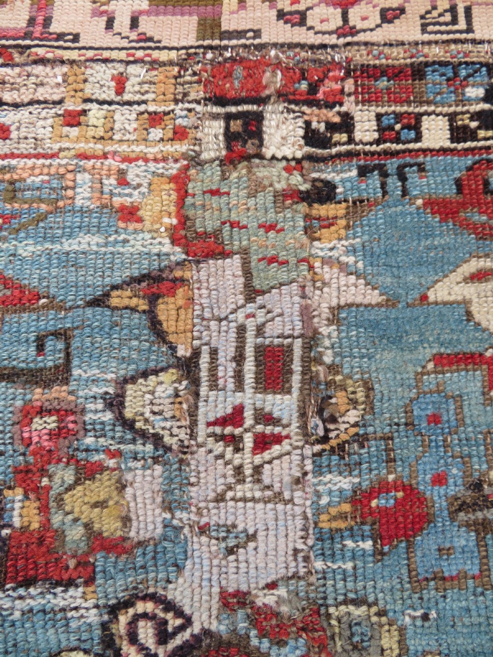 An antique hand-knotted Turkish Ladik wool prayer rug featuring a central pale blue mihrab niche, inverted tulip motifs, and multi-coloured geometric borders. View XII
