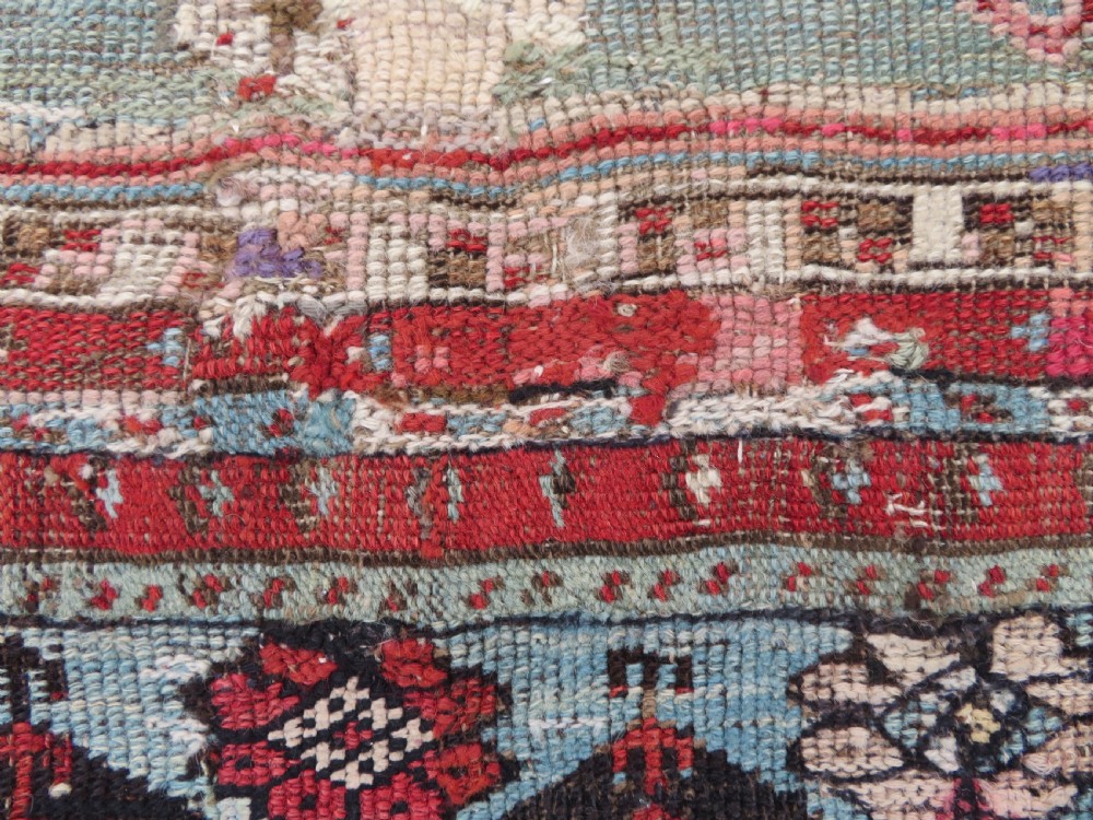 An antique hand-knotted Turkish Ladik wool prayer rug featuring a central pale blue mihrab niche, inverted tulip motifs, and multi-coloured geometric borders. View XVII