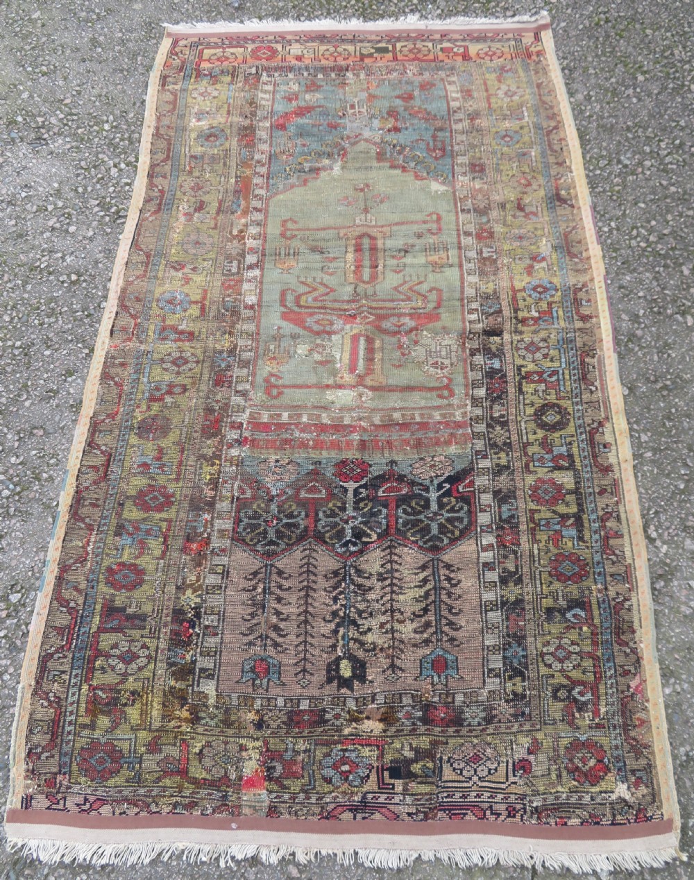 An antique hand-knotted Turkish Ladik wool prayer rug featuring a central pale blue mihrab niche, inverted tulip motifs, and multi-coloured geometric borders. View XVIII