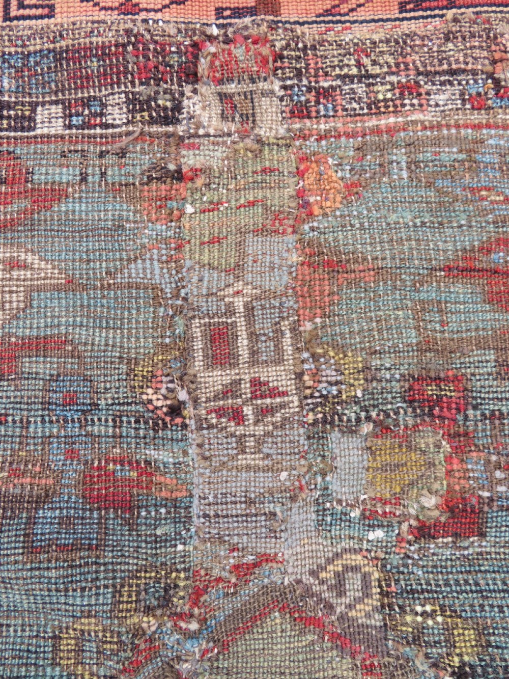 An antique hand-knotted Turkish Ladik wool prayer rug featuring a central pale blue mihrab niche, inverted tulip motifs, and multi-coloured geometric borders. View XXI
