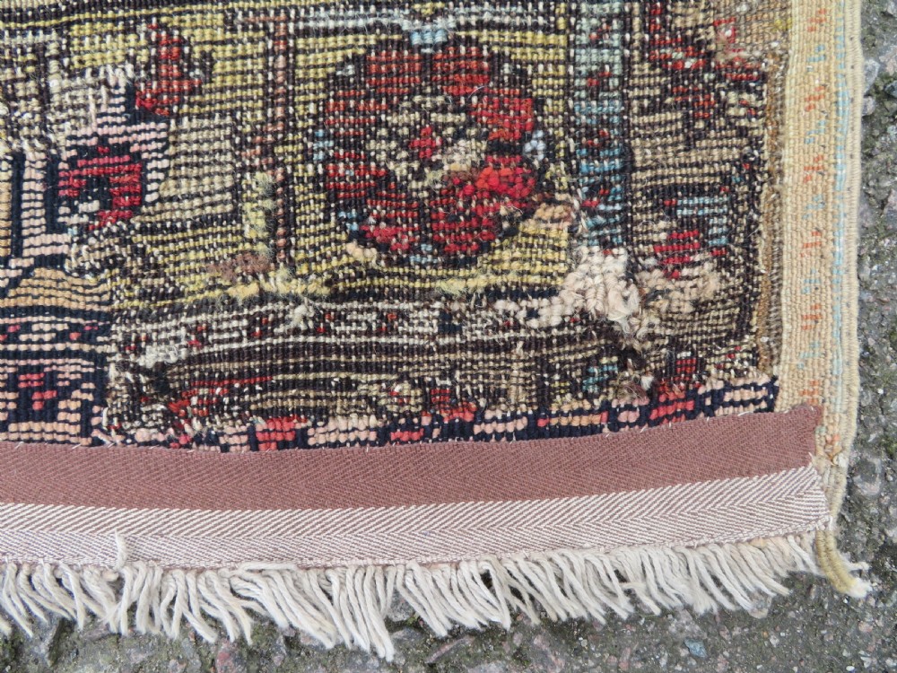 An antique hand-knotted Turkish Ladik wool prayer rug featuring a central pale blue mihrab niche, inverted tulip motifs, and multi-coloured geometric borders. View XXIV