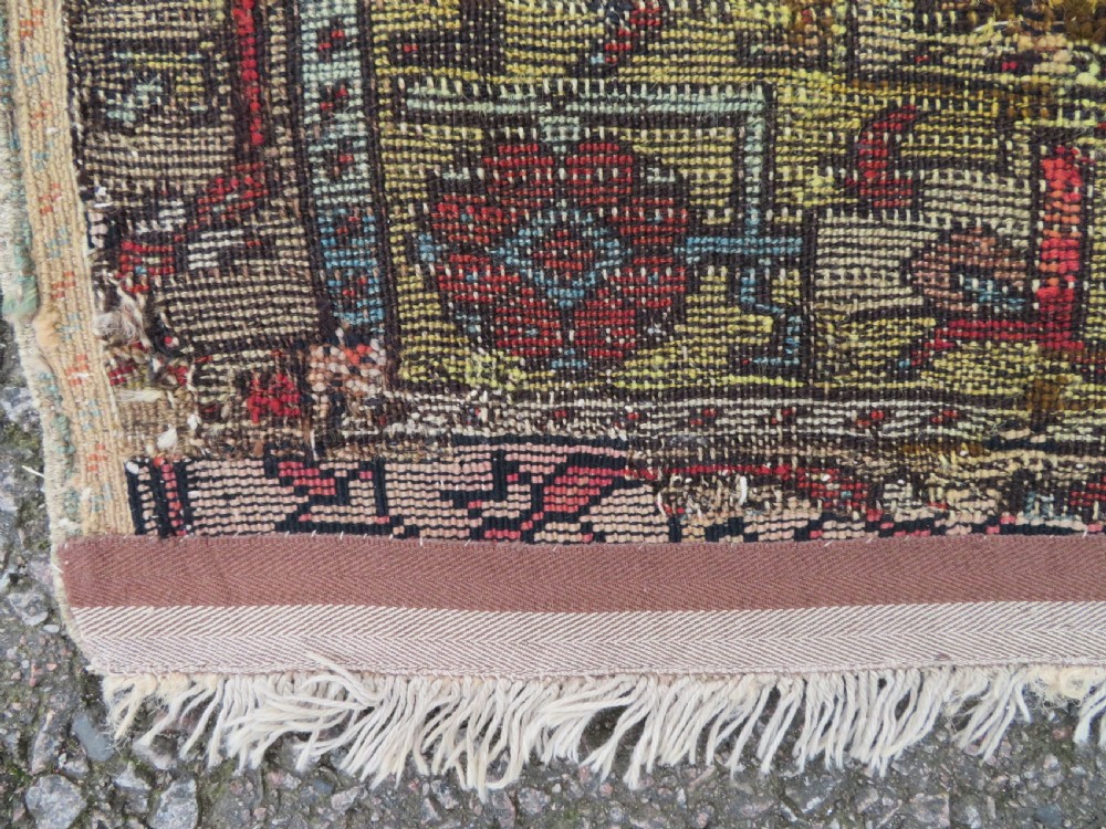 An antique hand-knotted Turkish Ladik wool prayer rug featuring a central pale blue mihrab niche, inverted tulip motifs, and multi-coloured geometric borders. View XXV