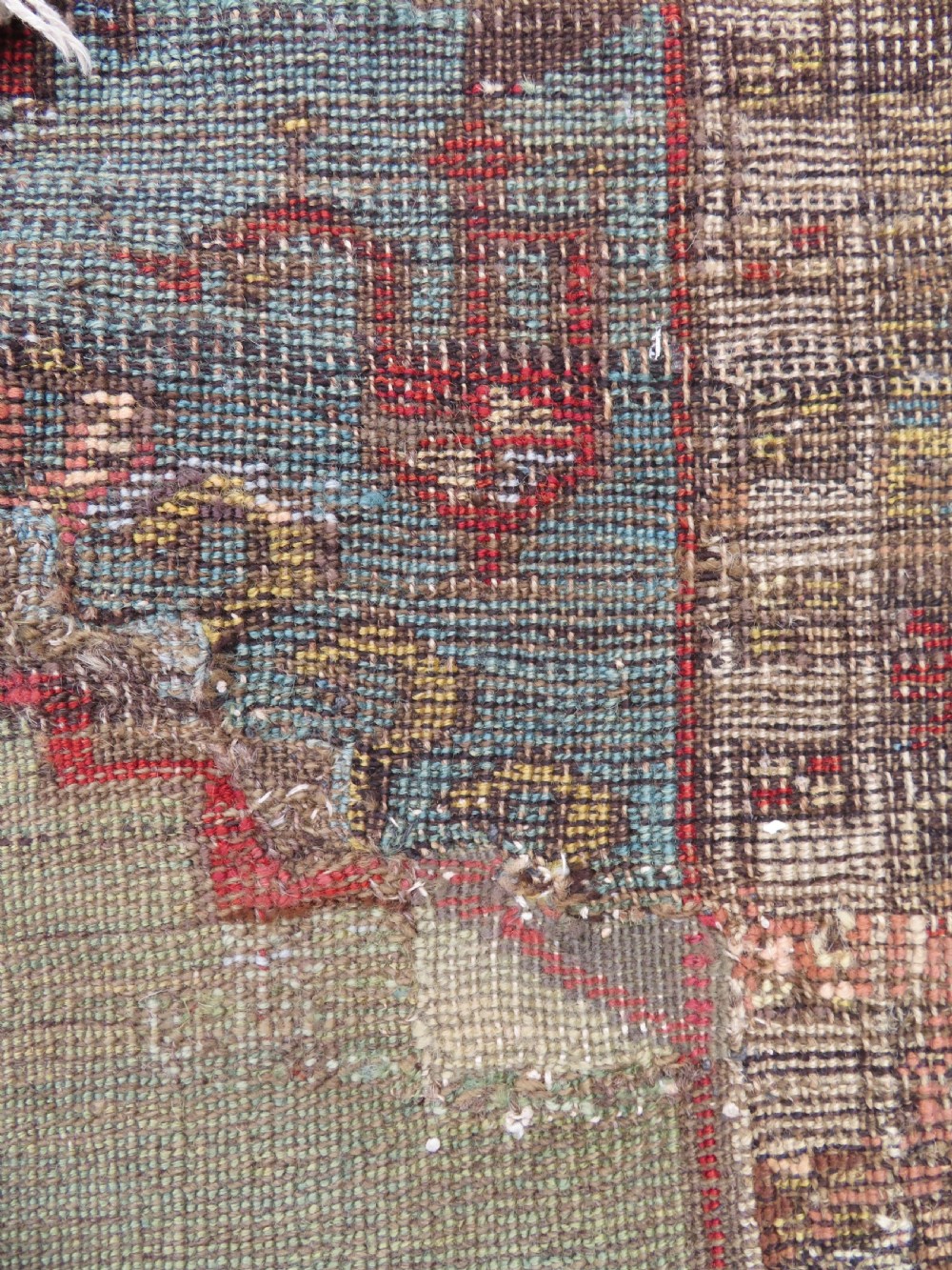 An antique hand-knotted Turkish Ladik wool prayer rug featuring a central pale blue mihrab niche, inverted tulip motifs, and multi-coloured geometric borders. View XXVIII