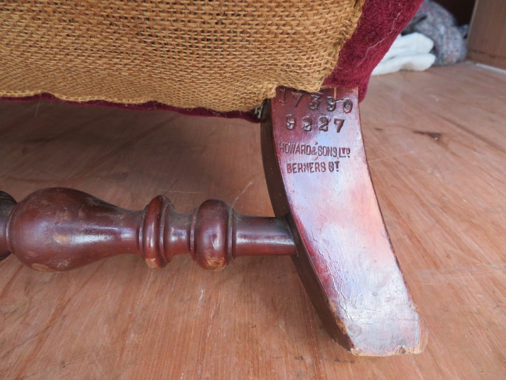 An antique wingback armchair upholstered in crimson velvet with turned wooden stretchers and cabriole front legs. View VI