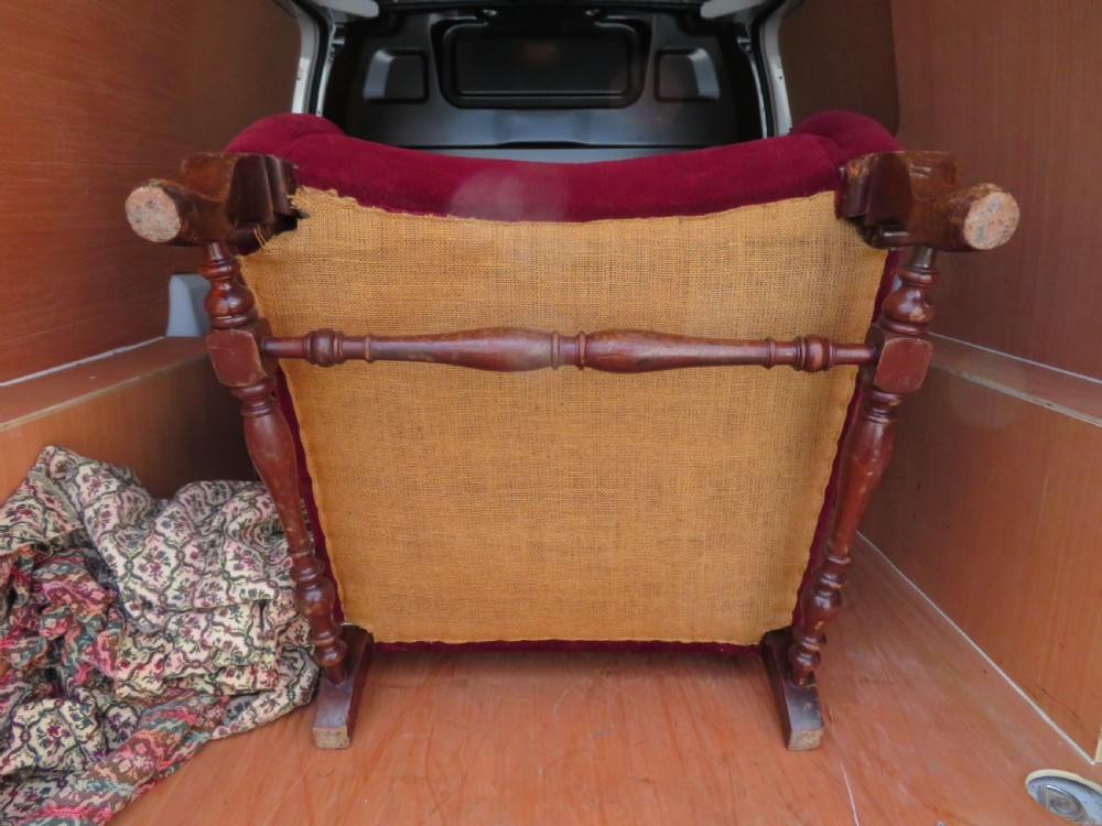 An antique wingback armchair upholstered in crimson velvet with turned wooden stretchers and cabriole front legs. View VIII