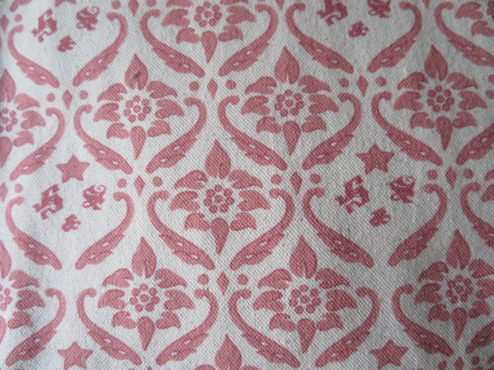 An upholstered Victorian armchair featuring patterned pink and cream fabric, turned dark timber legs, and brass castors. View III