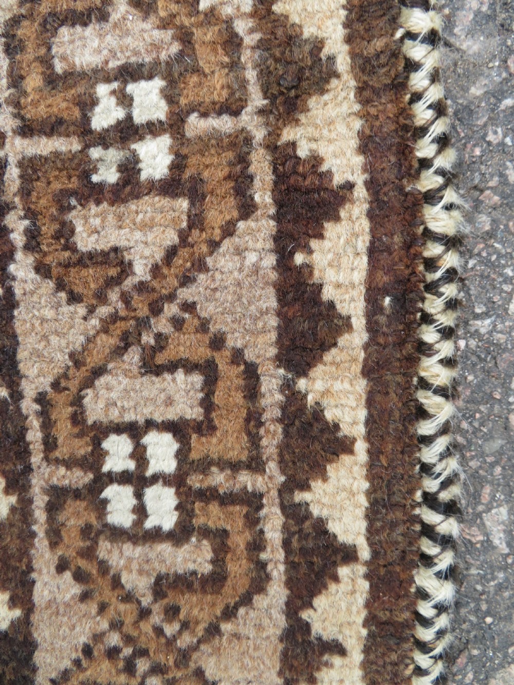 An antique hand-knotted wool Gabbeh rug with five central geometric diamond medallions in brown set against a cream field with a detailed geometric border. View VI