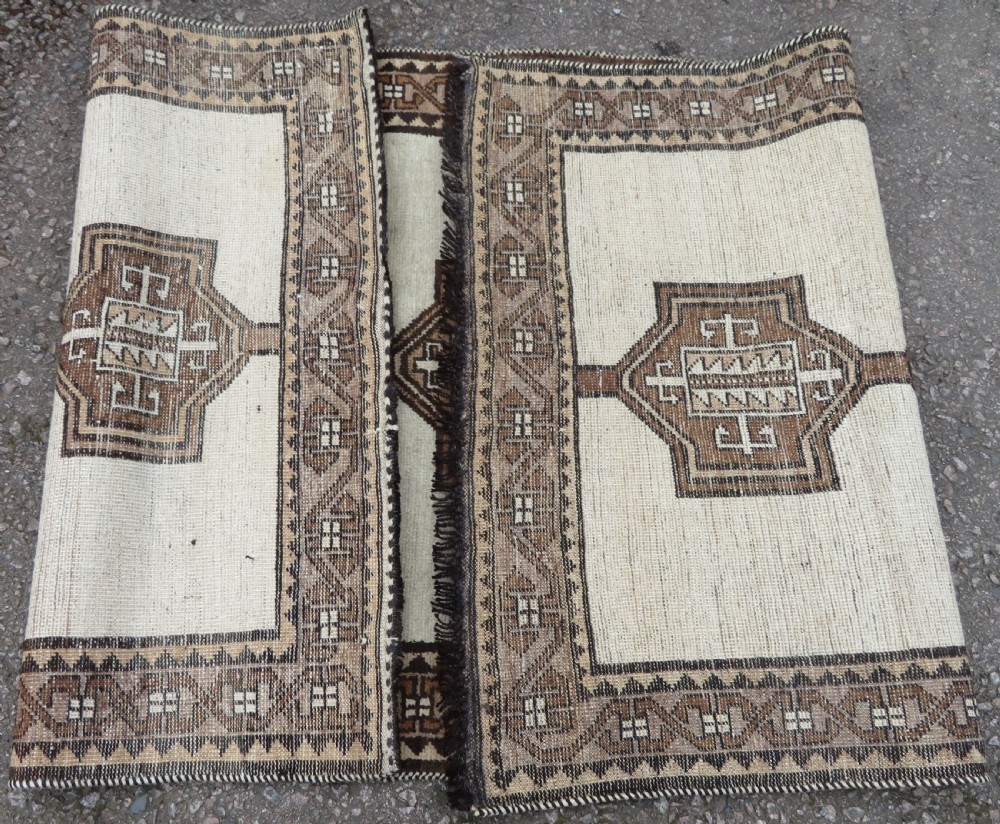 An antique hand-knotted wool Gabbeh rug with five central geometric diamond medallions in brown set against a cream field with a detailed geometric border. View XI