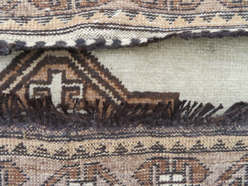 An antique hand-knotted wool Gabbeh rug with five central geometric diamond medallions in brown set against a cream field with a detailed geometric border. View XII