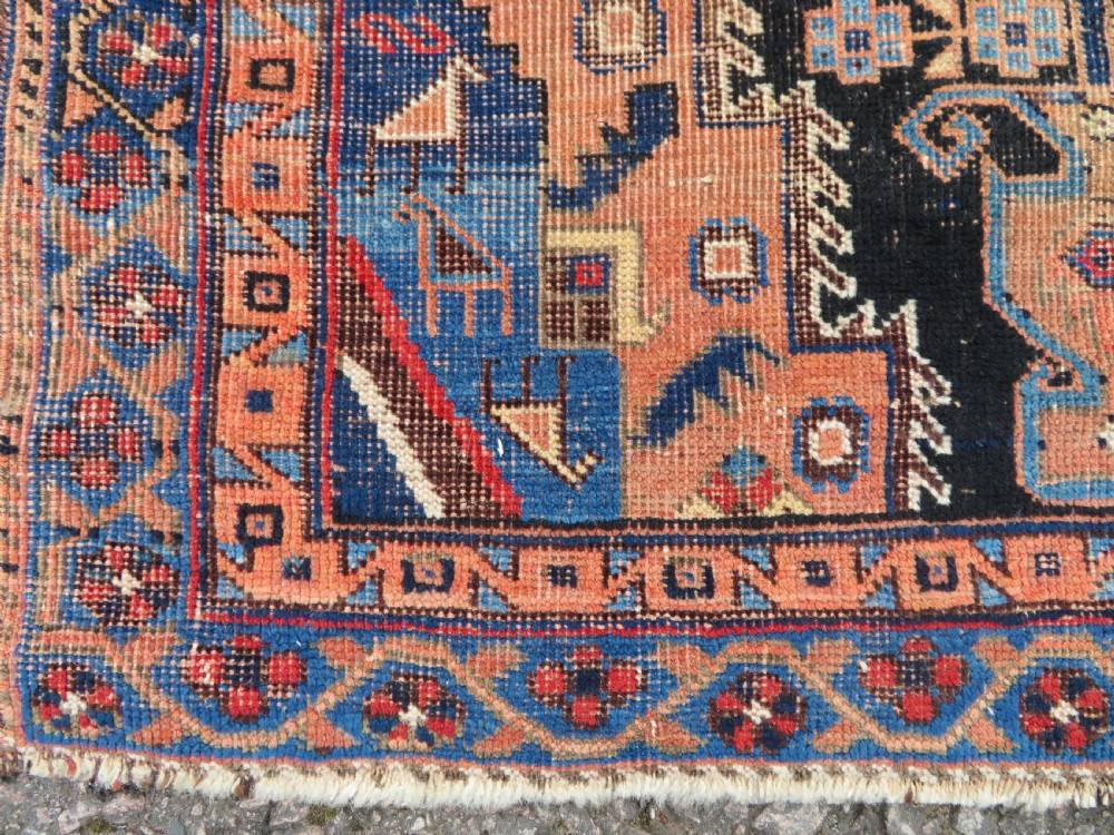 An antique hand-knotted Afshar wool rug featuring a central stepped geometric medallion in rust red and blue framed by intricate tribal borders. View II