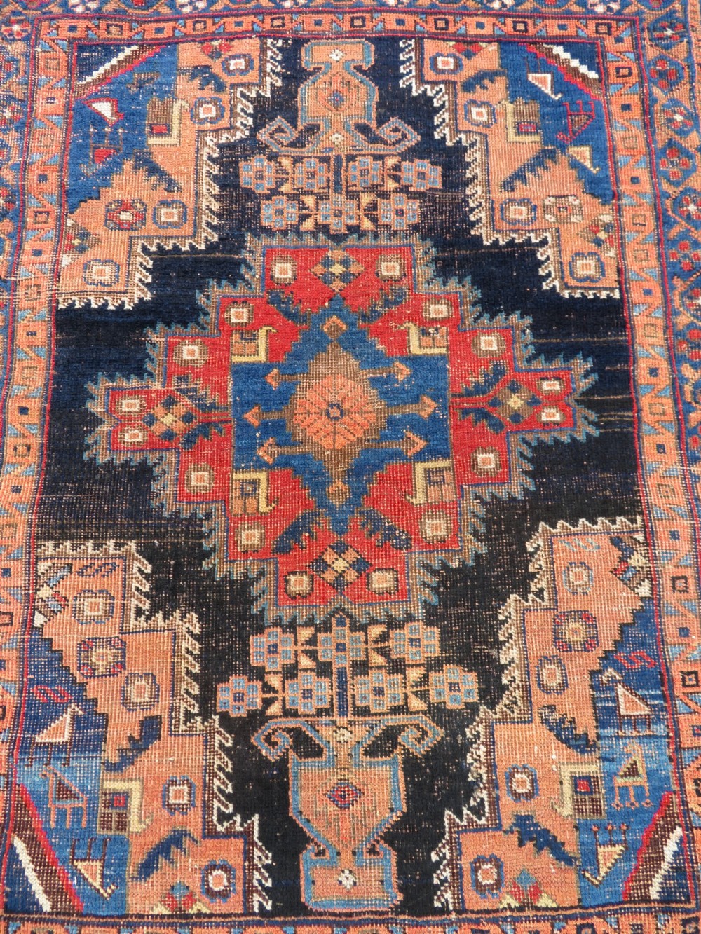 An antique hand-knotted Afshar wool rug featuring a central stepped geometric medallion in rust red and blue framed by intricate tribal borders. View III