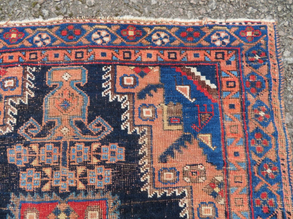 An antique hand-knotted Afshar wool rug featuring a central stepped geometric medallion in rust red and blue framed by intricate tribal borders. View V