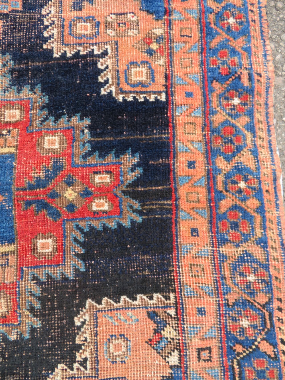 An antique hand-knotted Afshar wool rug featuring a central stepped geometric medallion in rust red and blue framed by intricate tribal borders. View VI
