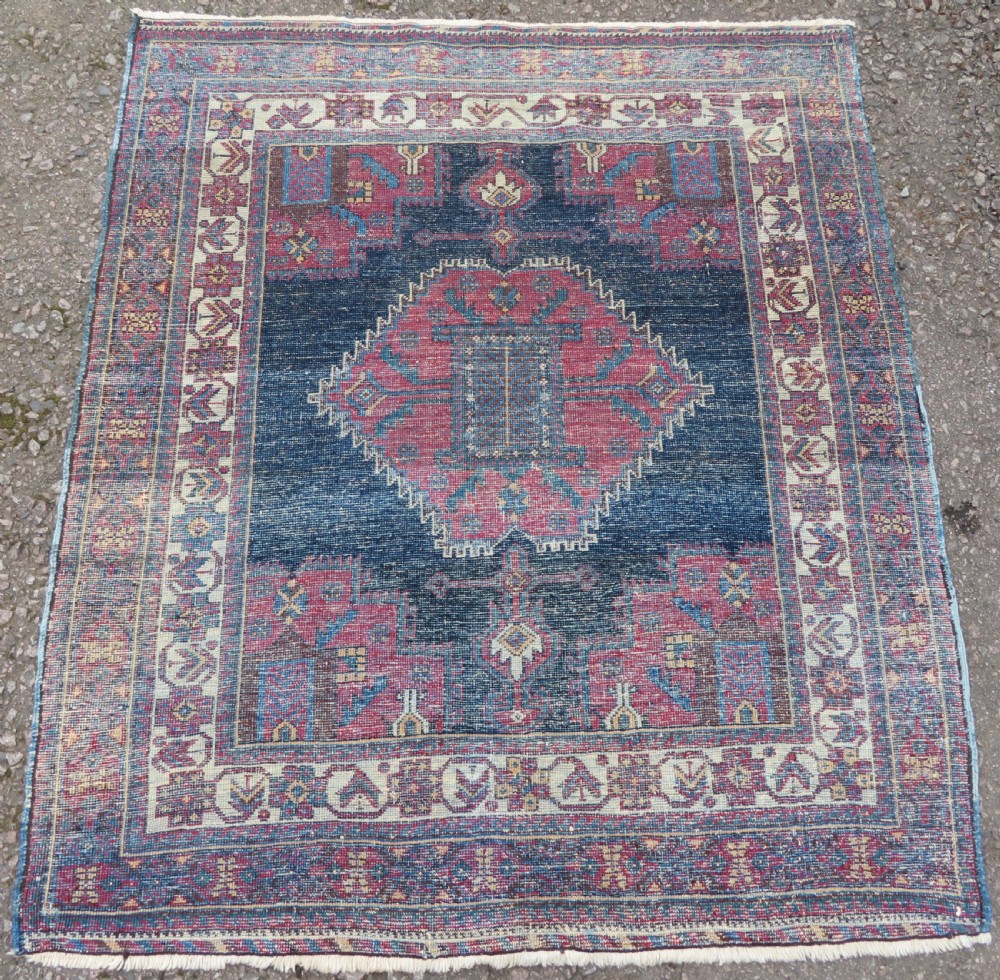 A hand-knotted antique Afshar tribal wool rug featuring a red stepped medallion on an indigo blue field surrounded by geometric borders. View IX