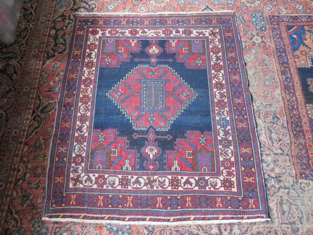 A hand-knotted antique Afshar tribal wool rug featuring a red stepped medallion on an indigo blue field surrounded by geometric borders. View XIII