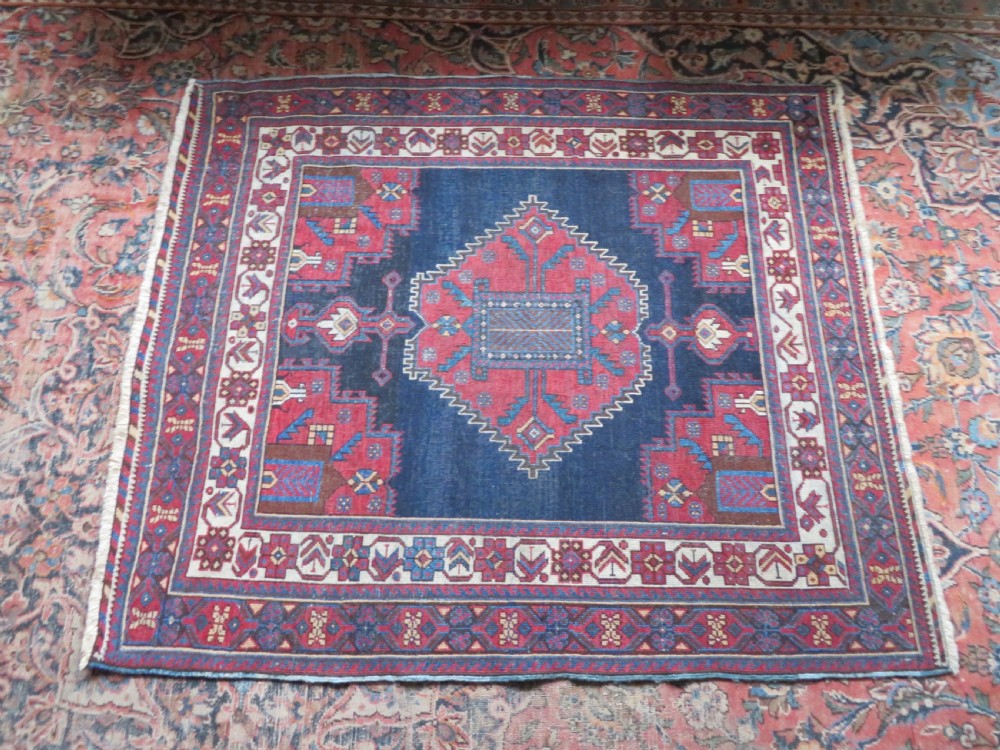 A hand-knotted antique Afshar tribal wool rug featuring a red stepped medallion on an indigo blue field surrounded by geometric borders. View XIV