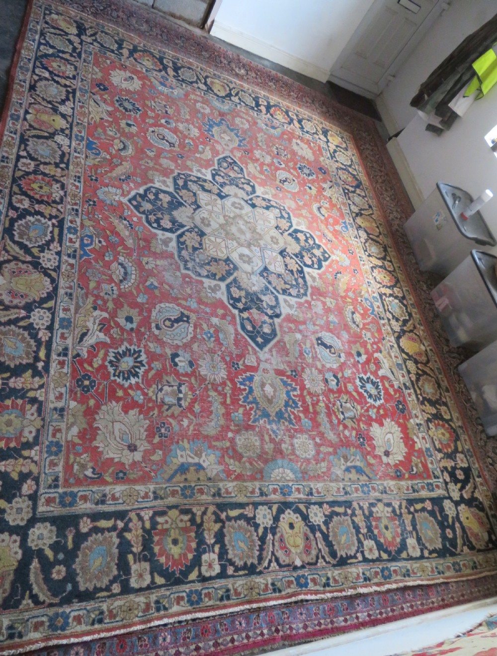 An antique hand-knotted Tabriz wool carpet featuring a central navy and cream medallion on a terracotta field with intricate floral borders. View III