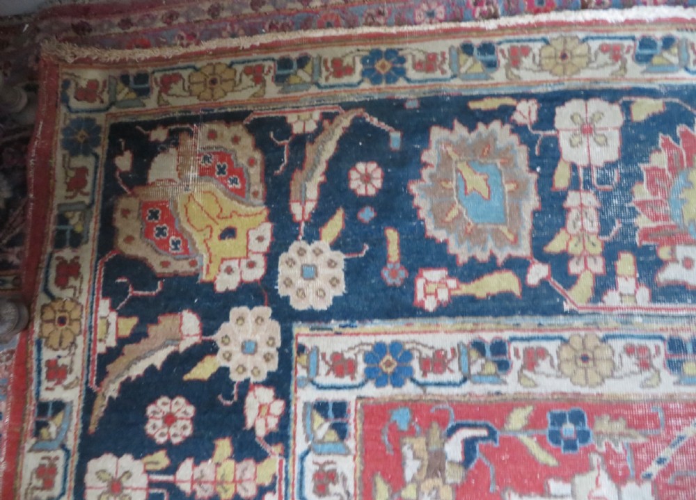 An antique hand-knotted Tabriz wool carpet featuring a central navy and cream medallion on a terracotta field with intricate floral borders. View X
