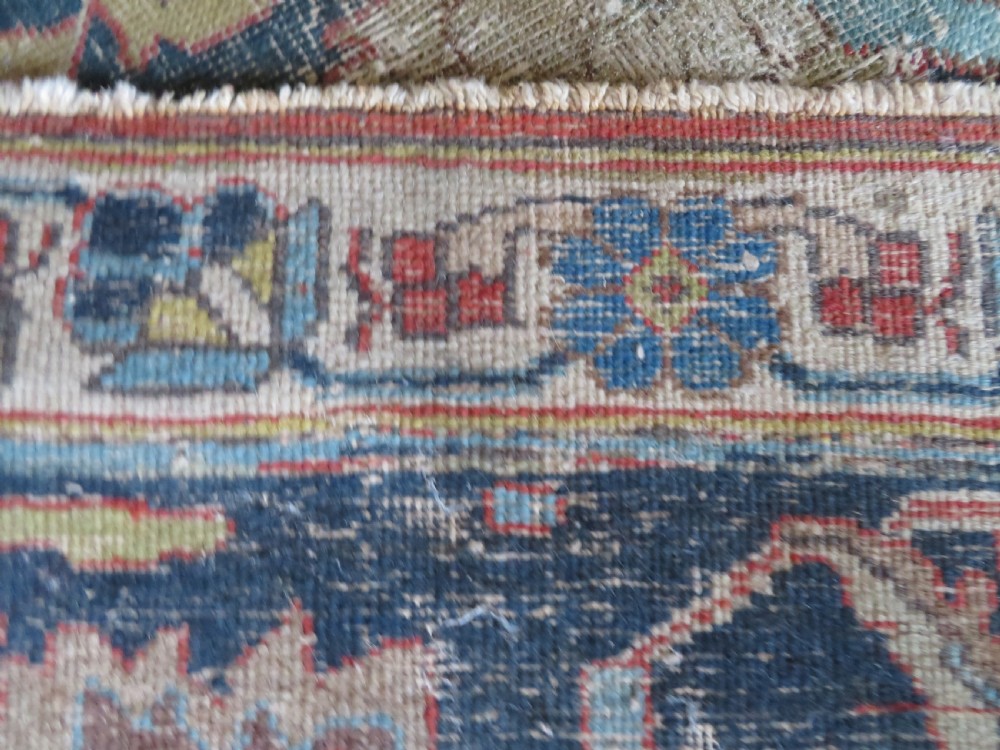 An antique hand-knotted Tabriz wool carpet featuring a central navy and cream medallion on a terracotta field with intricate floral borders. View XIX