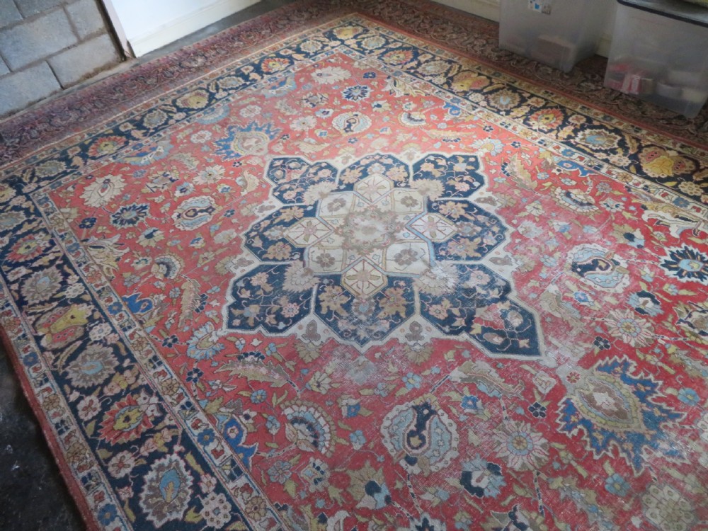 An antique hand-knotted Tabriz wool carpet featuring a central navy and cream medallion on a terracotta field with intricate floral borders. View XXI