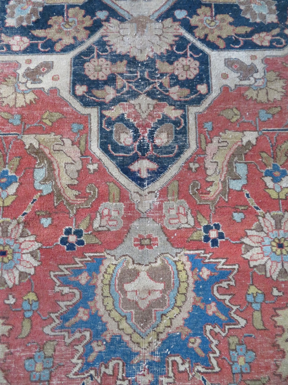 An antique hand-knotted Tabriz wool carpet featuring a central navy and cream medallion on a terracotta field with intricate floral borders. View XXIV