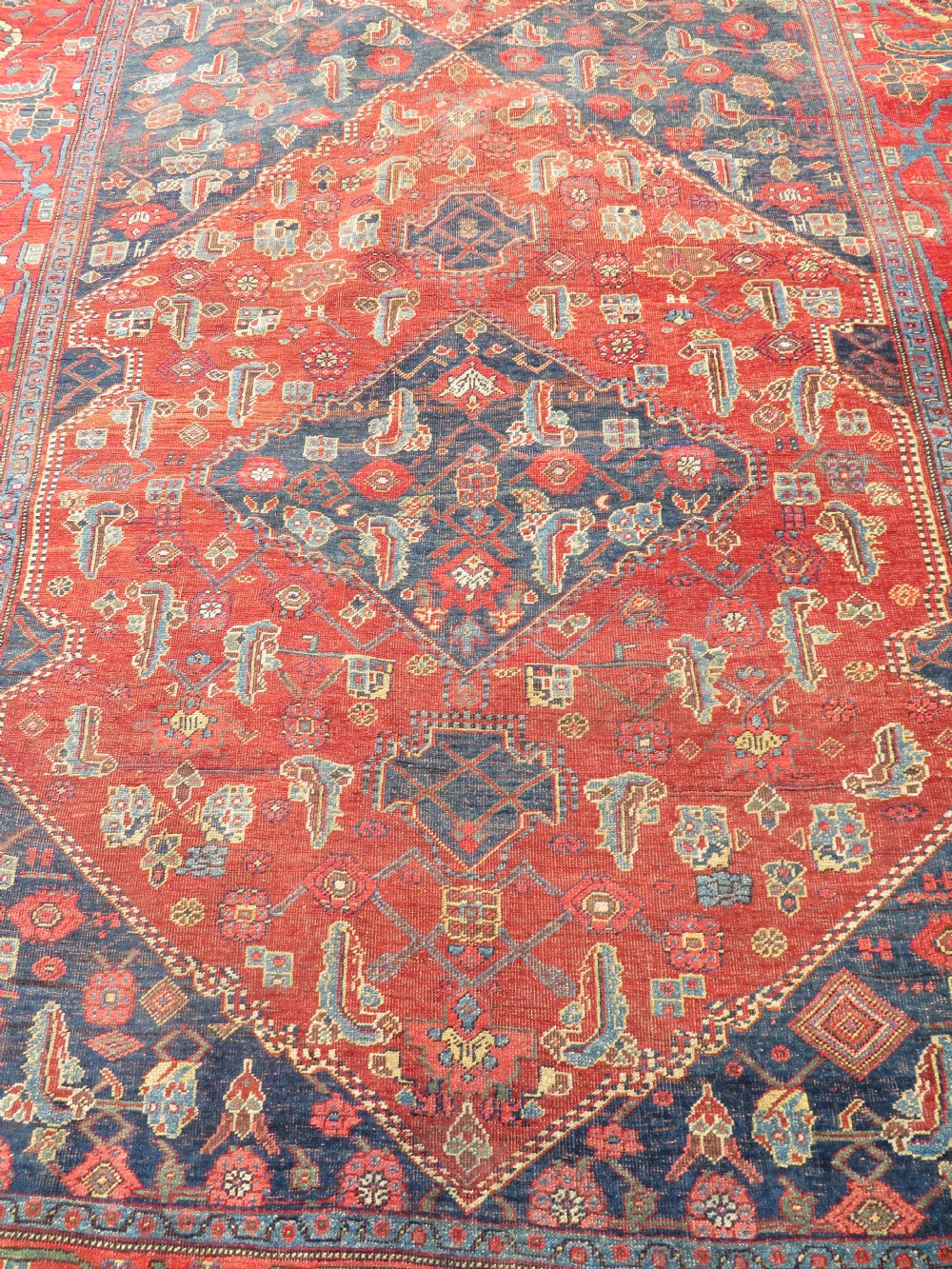 An antique Kurdish Bidjar Kelleh hand-knotted carpet featuring geometric diamond medallions on a terracotta red field with dark navy blue borders. View VIII