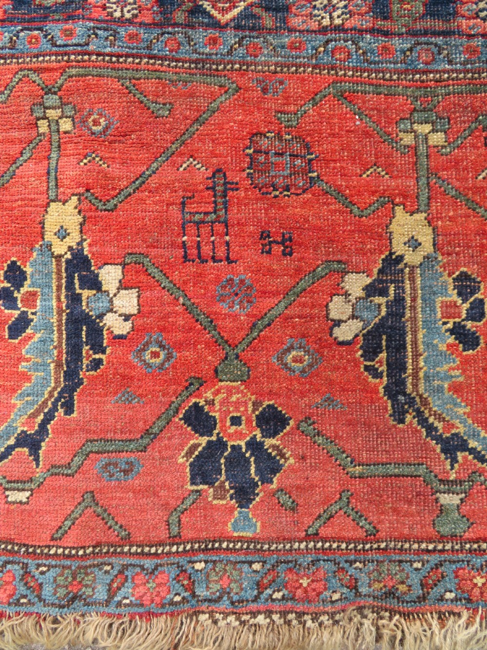 An antique Kurdish Bidjar Kelleh hand-knotted carpet featuring geometric diamond medallions on a terracotta red field with dark navy blue borders. View IX