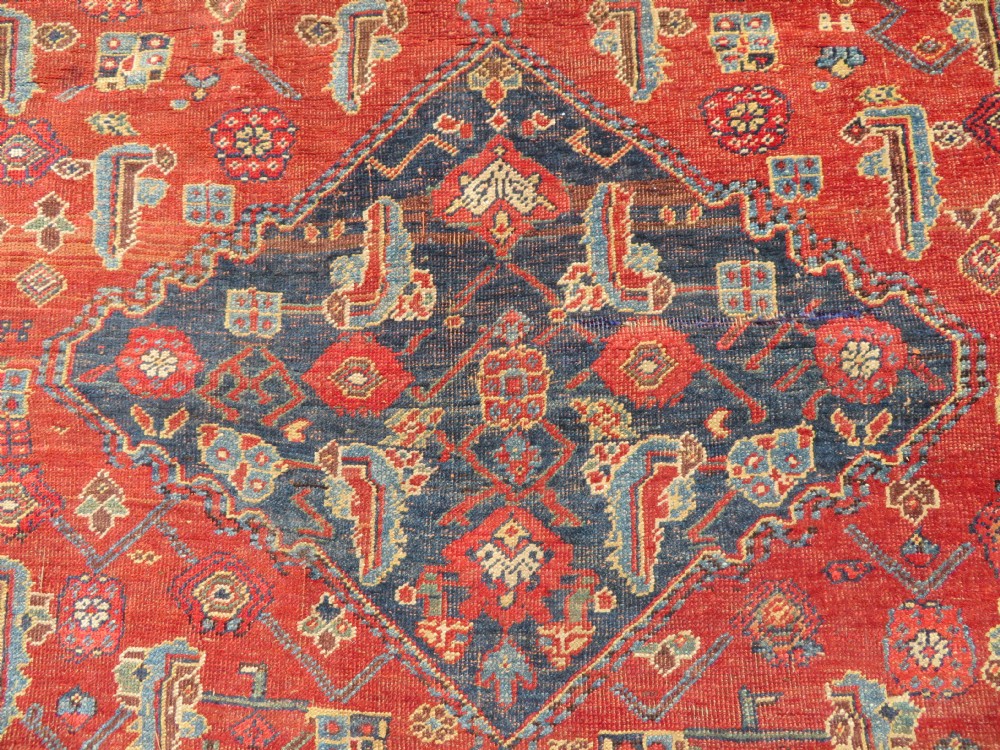 An antique Kurdish Bidjar Kelleh hand-knotted carpet featuring geometric diamond medallions on a terracotta red field with dark navy blue borders. View XI