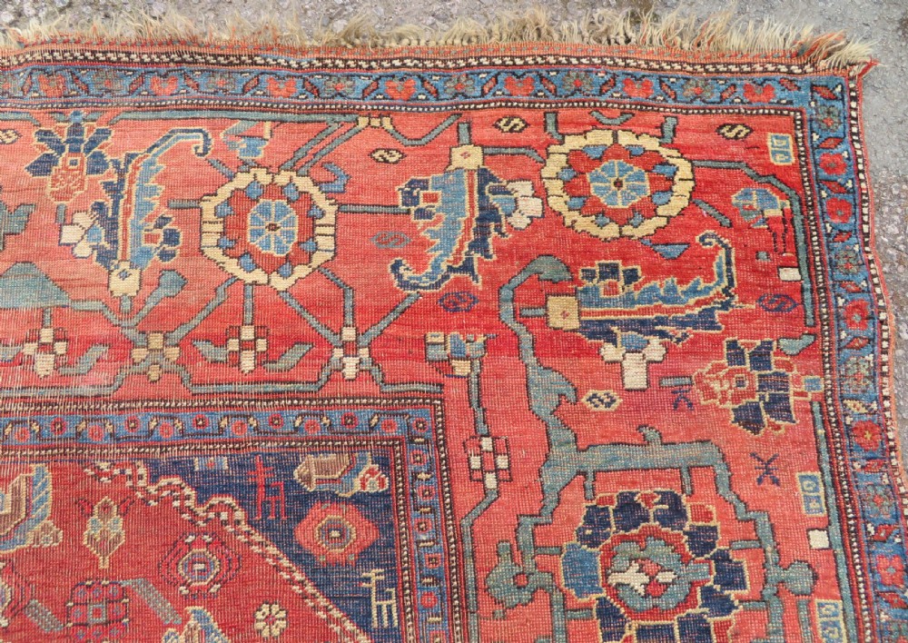 An antique Kurdish Bidjar Kelleh hand-knotted carpet featuring geometric diamond medallions on a terracotta red field with dark navy blue borders. View XV