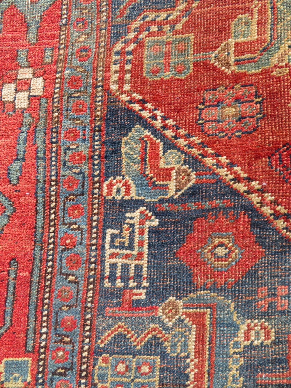 An antique Kurdish Bidjar Kelleh hand-knotted carpet featuring geometric diamond medallions on a terracotta red field with dark navy blue borders. View XVIII