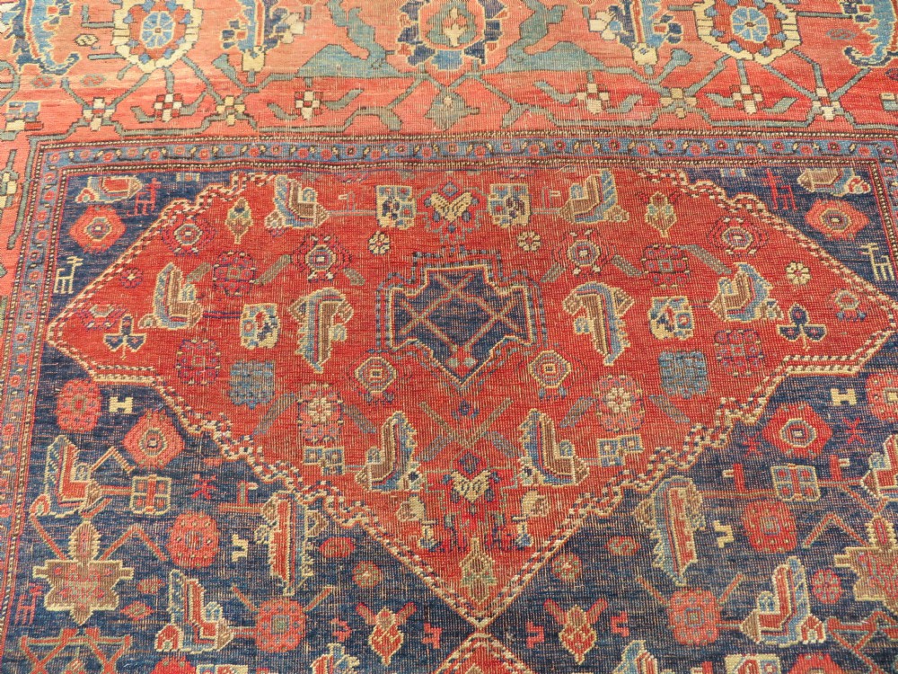 An antique Kurdish Bidjar Kelleh hand-knotted carpet featuring geometric diamond medallions on a terracotta red field with dark navy blue borders. View XX