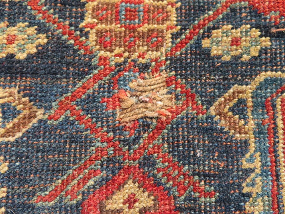 An antique Kurdish Bidjar Kelleh hand-knotted carpet featuring geometric diamond medallions on a terracotta red field with dark navy blue borders. View XXII