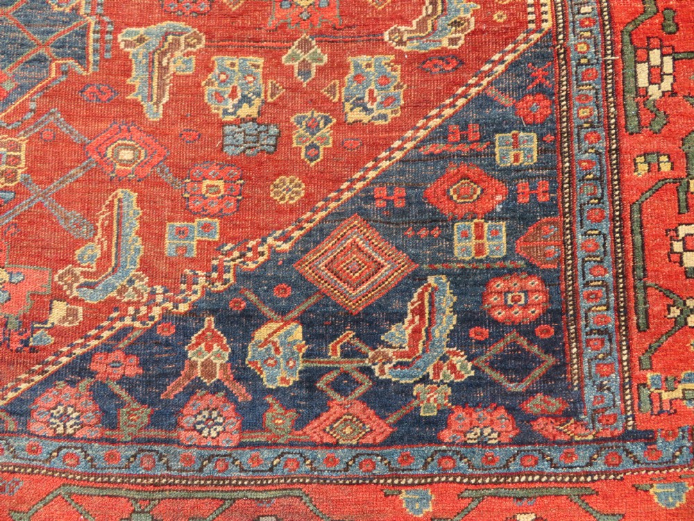 An antique Kurdish Bidjar Kelleh hand-knotted carpet featuring geometric diamond medallions on a terracotta red field with dark navy blue borders. View XXIII