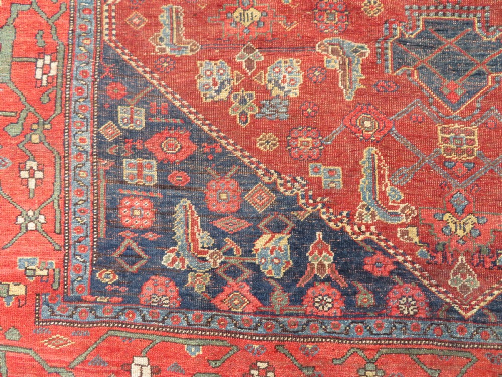 An antique Kurdish Bidjar Kelleh hand-knotted carpet featuring geometric diamond medallions on a terracotta red field with dark navy blue borders. View XXIV