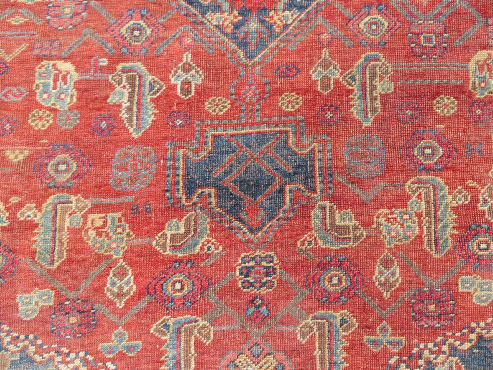 An antique Kurdish Bidjar Kelleh hand-knotted carpet featuring geometric diamond medallions on a terracotta red field with dark navy blue borders. View XXVII