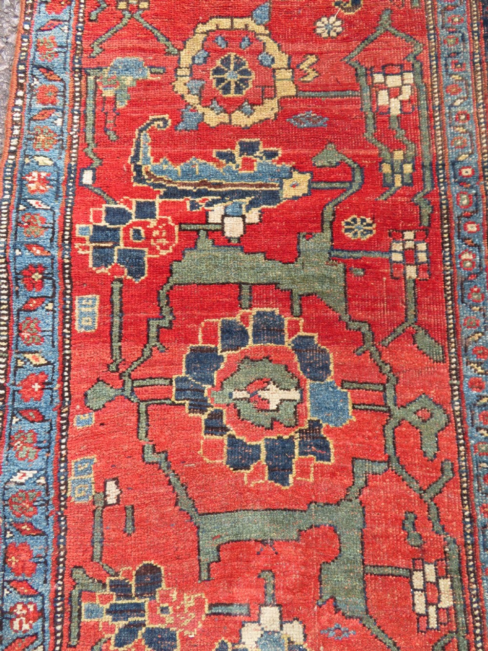 An antique Kurdish Bidjar Kelleh hand-knotted carpet featuring geometric diamond medallions on a terracotta red field with dark navy blue borders. View XXVIII