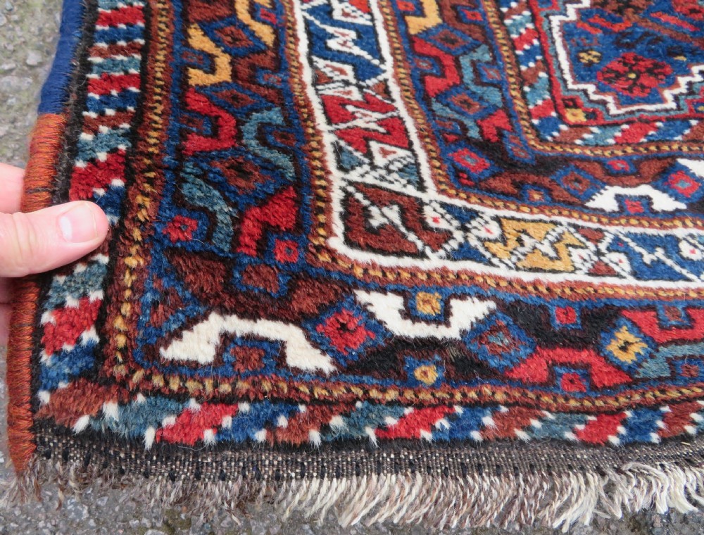An antique Khamseh hand-knotted wool tribal rug featuring three central diamond medallions surrounded by small bird and geometric motifs in deep blue, terracotta red, and cream. View IX