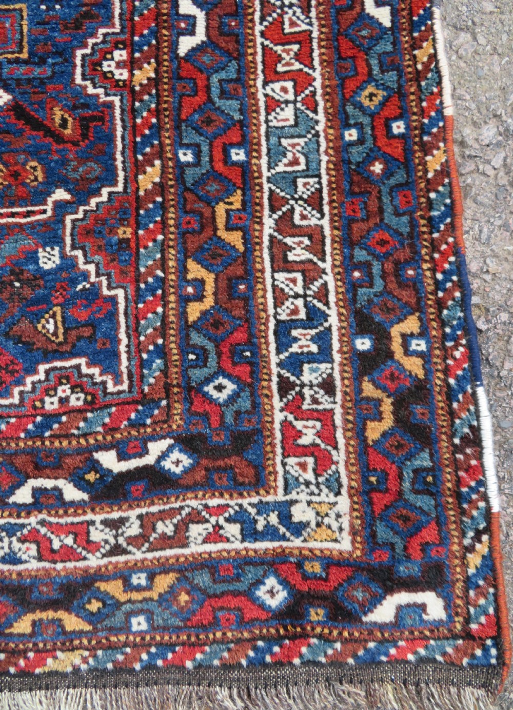 An antique Khamseh hand-knotted wool tribal rug featuring three central diamond medallions surrounded by small bird and geometric motifs in deep blue, terracotta red, and cream. View XI