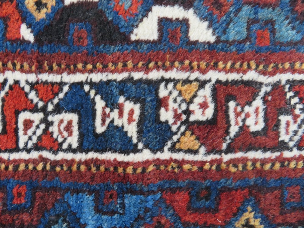 An antique Khamseh hand-knotted wool tribal rug featuring three central diamond medallions surrounded by small bird and geometric motifs in deep blue, terracotta red, and cream. View XV