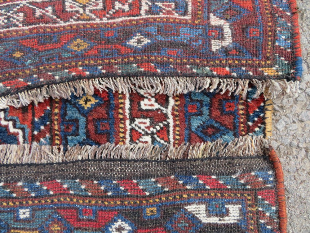 An antique Khamseh hand-knotted wool tribal rug featuring three central diamond medallions surrounded by small bird and geometric motifs in deep blue, terracotta red, and cream. View XVIII
